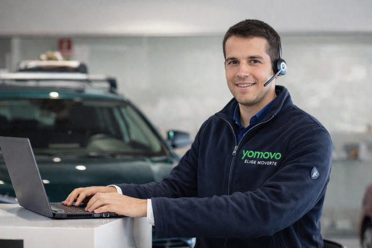 asesor yomovo con portátil dentro de un concesionario